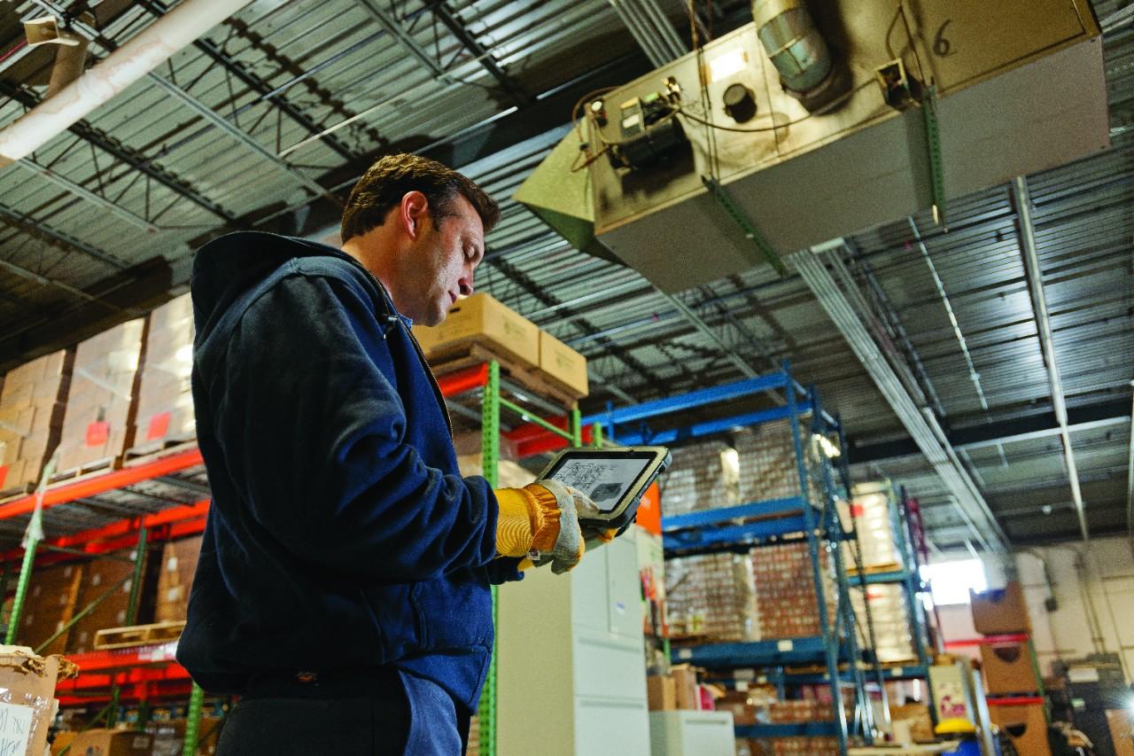Warehouse Worker Solving Solutions Using a ET50 Tablet to Check Inventory